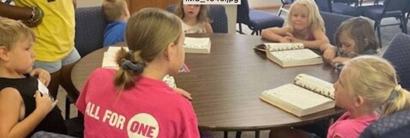 Children work on church projects around a round table